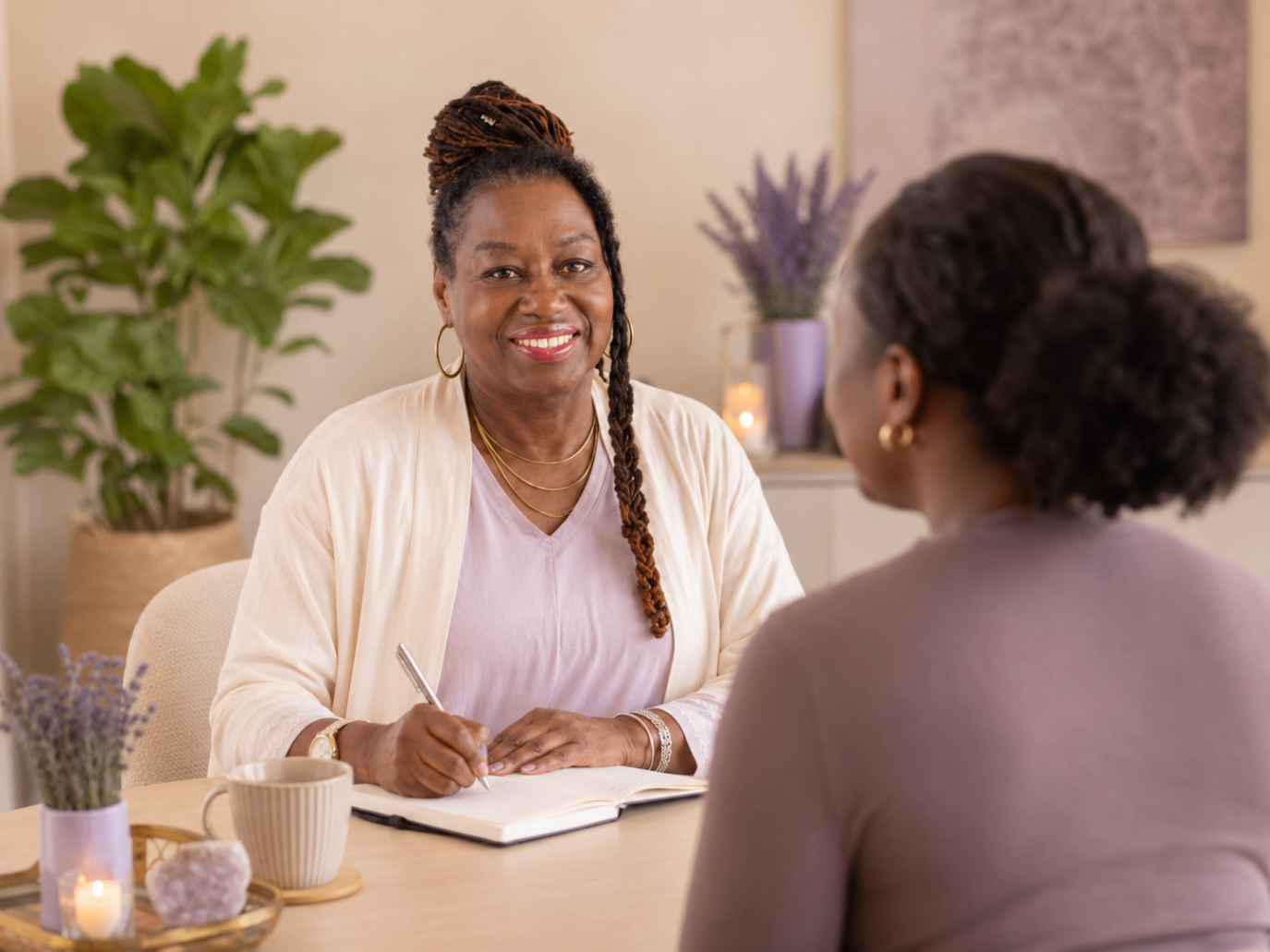 Hilary Rose in conversation with a client, taking notes at a table